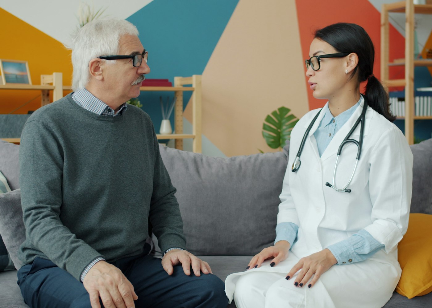 Médica conversando com um senhor na clínica