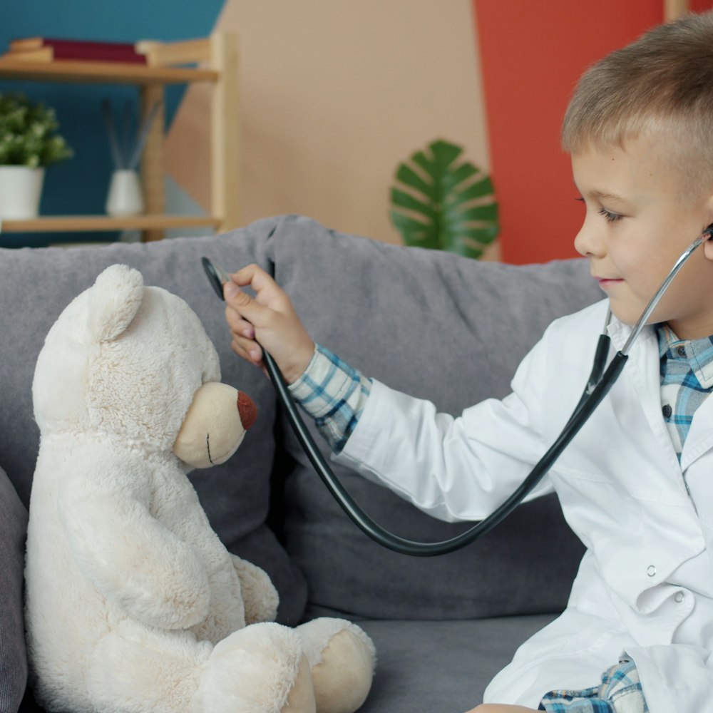 Menino brincando de médico com ursinho